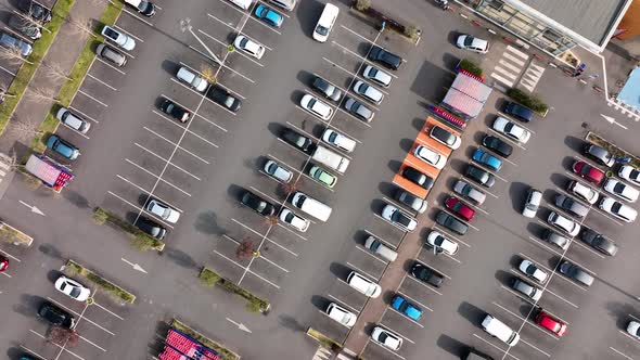 Aerial View of Many Colorful Cars Parked on Parking Lot with Lines and Markings for Parking Places alt