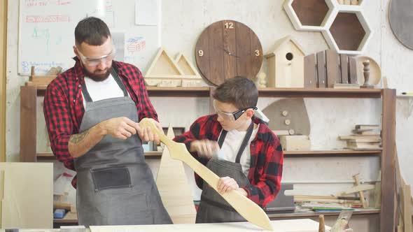 Little Male Woodworker Creating His Dream and His Dad Is Helping Him alt