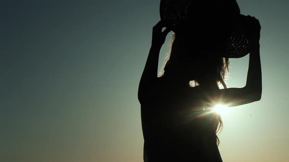 Girl Puts On A Hat (Silhouette)