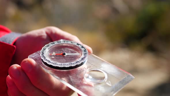Close up on an old scratched magnetic compass being used in an emergency survival situation to find alt