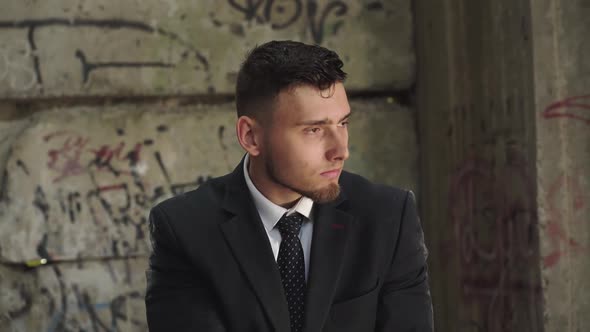 Man in Suit Tries to Shoot with Pistol in Abandoned Building alt