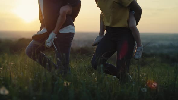 Low section of parents with kids walking at the meadow in summer day. Shot with RED helium camera in alt