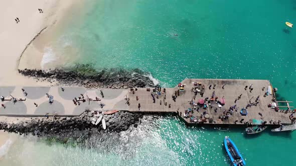 Aerial footage of the famous pier at Cape Verde, fishermen with fishermen's wives selling the fish alt