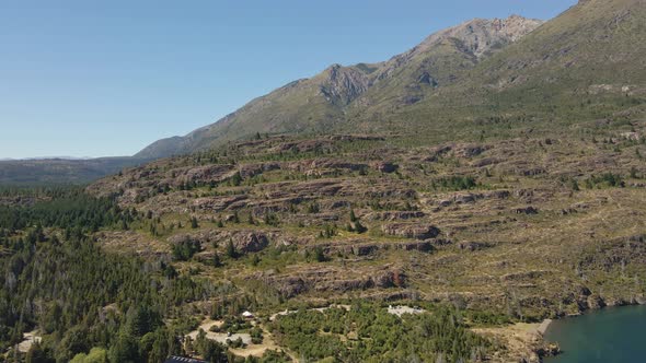 Aerial dolly in of Andean mountains surrounded by pine trees near Epuyen lake, Patagonia Argentina alt