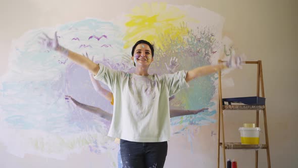 Lady with Hands in Coloured Paint Dances with Children