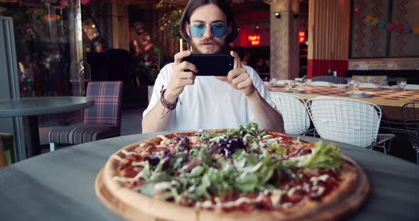 Male Hippie Taking Photo of Pizza