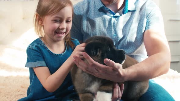 Cheerful father and daughter caressing pet