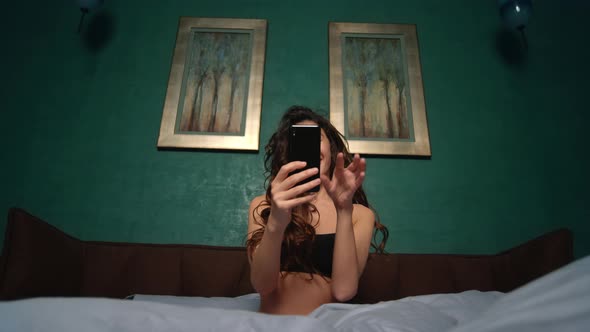 Woman Having Video Call Mobile Phone in Bed. Nude Girl Holding Cellphone Hand. alt