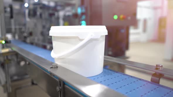 a white bucket with the finished product moves along the conveyor