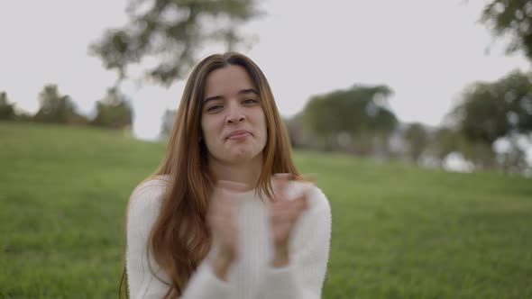Young Woman Smiles and Claps Hands Toward Camera Close Static View alt