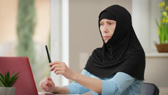 Mature Muslim Woman in Hijab Training Eyes Following Pen with Eyesight Rubbing Eyes alt