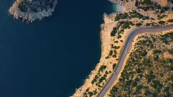 Blue Sea Rocky Coast and Asphalt Mountain Road alt