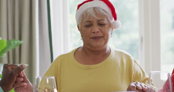 Happy diverse senior female and male friends celebrating meal at christmas time alt