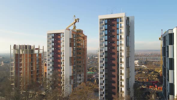 Aerial view of high tower crane and residential apartment buildings under construction. Real alt