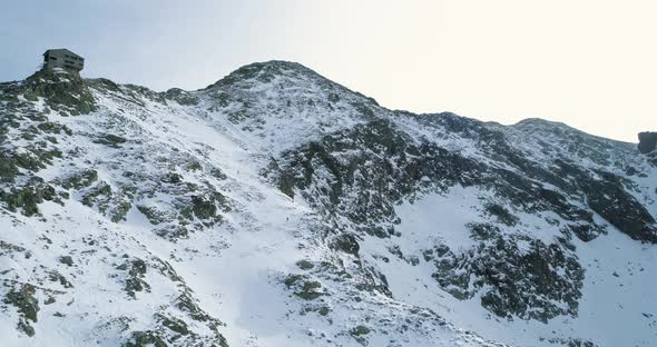Backward Aerial Over Winter Snowy Mountain with Mountaineering Skier People Walking Up Climbing