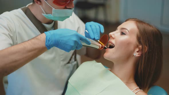 Young Pretty Girl Is in Dental Cabinet on Treatment and Dental Cleansing.  alt
