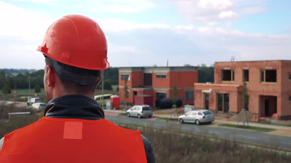 A Construction Worker (The Back of His Head To the Camera) Looks Around a Site - Closeup alt