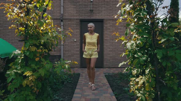Woman Walking in Her Green Yard