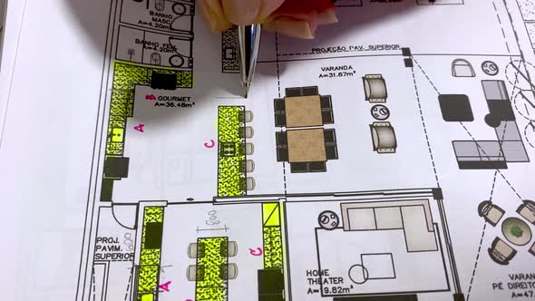 Architect making notes on the blueprints of a home design project alt