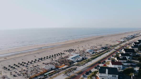 Drone Flies Over Ocean Beach in the City on a Summer Day