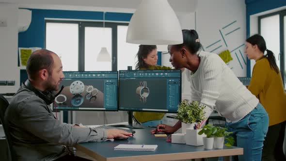 Multiethnic Team Discussing About Industrial Project Using Dual Monitors Setup alt