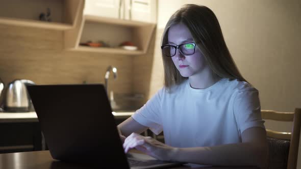 Woman Overtime Working From Home and Drinking Coffee, Laptop on the Kitchen