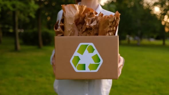 Young unidentified woman is holding a box with paper bags