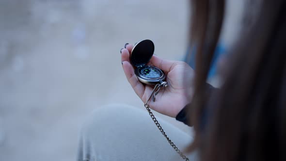 Close View of Young Woman’s Hand Using Metal Compass and Closing It alt