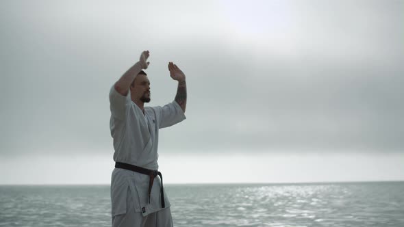Taekwondo Man Training Strength Near Calm Sea alt