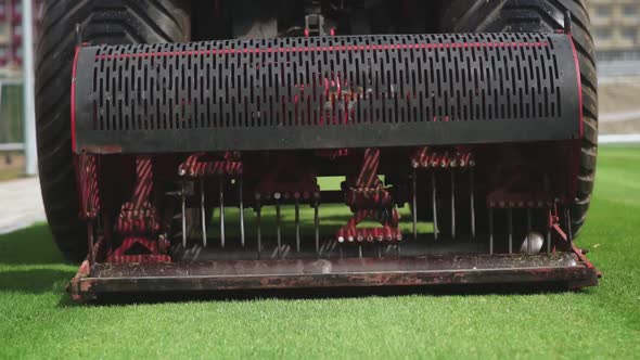 Close Up of Lawn Mower Pierces the Lawn Grass in a Football Stadium alt