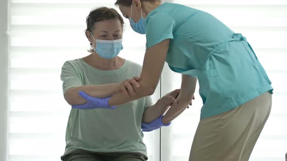 Doctor or Nurse is Helping an Elderly Woman to Get to Her Feet alt