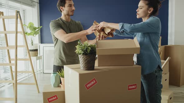 Video of couple packing things to boxes while moving house. Shot with RED helium camera in 8K alt