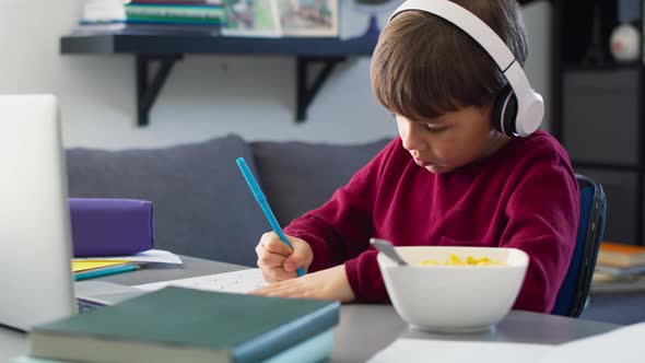Handheld video of boy doing homework during breakfast. Shot with RED helium camera in 8K alt