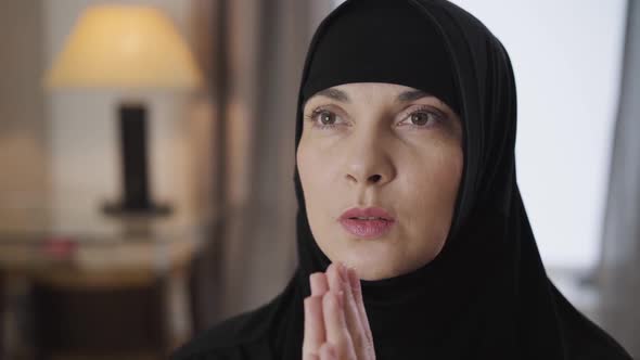 Close-up Face of Young Beautiful Muslim Woman Holding Hands Together and Praying. Lady in Black alt