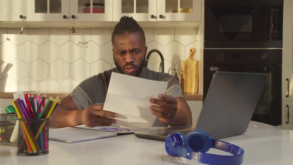 Shocked Handsome African American Man Receiving Eviction Notice at Home alt