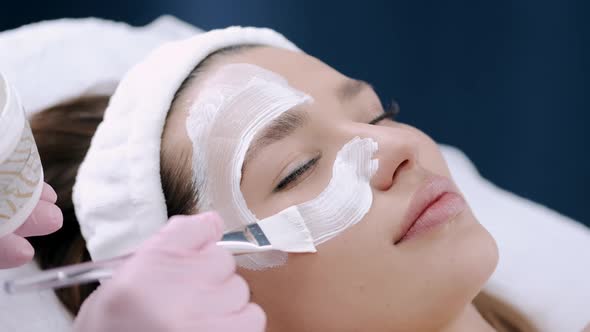 Cropped View of Beautician Putting Facial Mask on Face alt