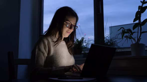 Woman using laptop at home in the evening