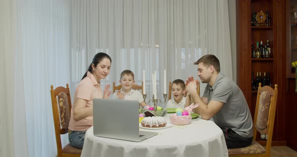 Parents with Two Teenage Boys Talking Video Call Using a Laptop Browsing Online TV Streams Enjoying alt