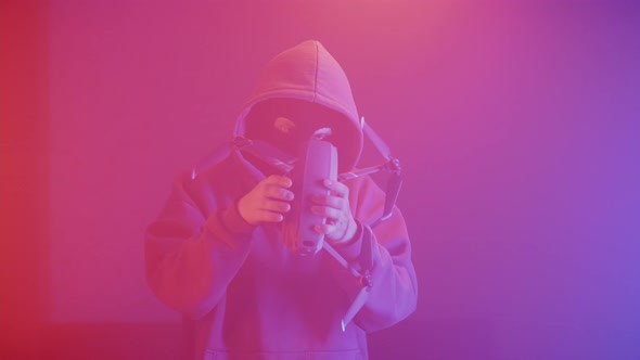 a criminal in a mask with a quadcopter in his hands alt