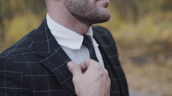 Handsome Gentleman in Sunglasses Corrects Suit and Looks Aside alt