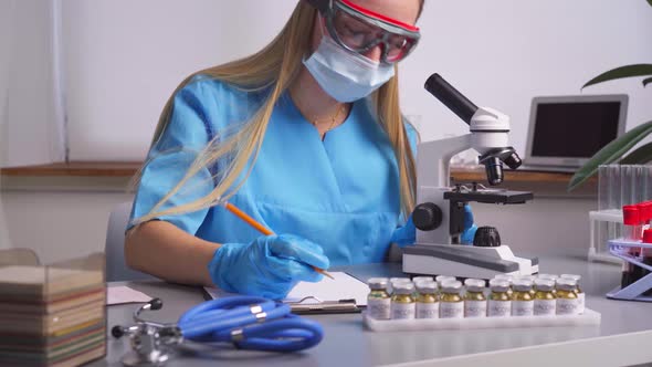 Woman Laboratory Worker Taking Notes About Blood Samples alt