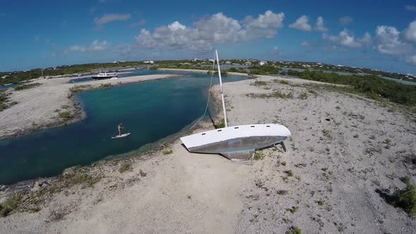 Aerial shot of young woman sup standup paddleboarding in the Caribbean. alt