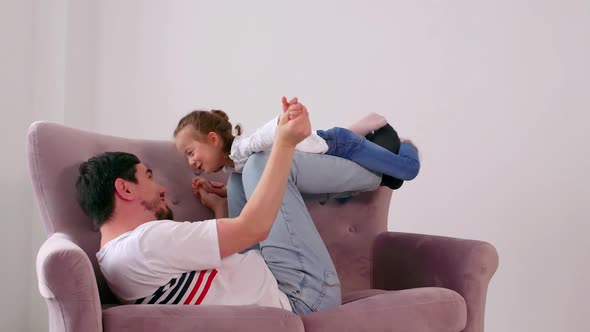 Happy family young dad lifting cute little kid daughter up fly as airplane