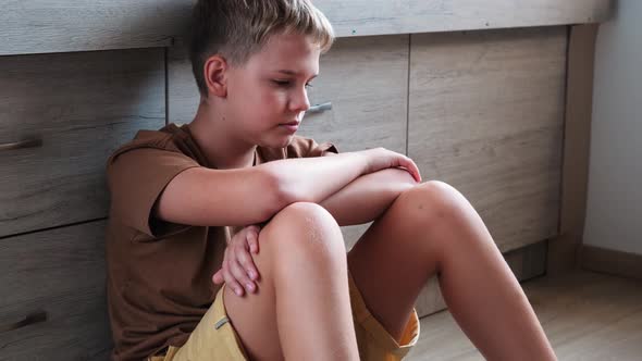 Sad Teenage Boy Sitting Alone on Floor in Bedroom Thinking About the Problem alt