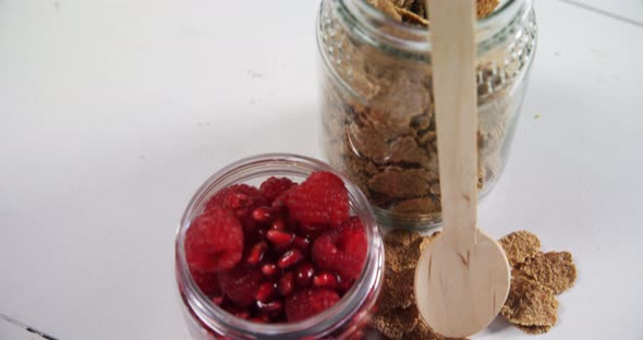 Wheat flakes with raspberries and pomegranates 4k alt