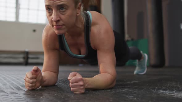 Close up of fit caucasian woman performing plank exercise at the gym alt