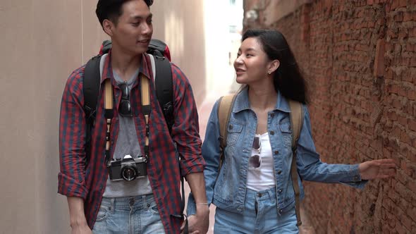 Young couple backpacker Asian tourists walking at old alley in Bangkok Thailand