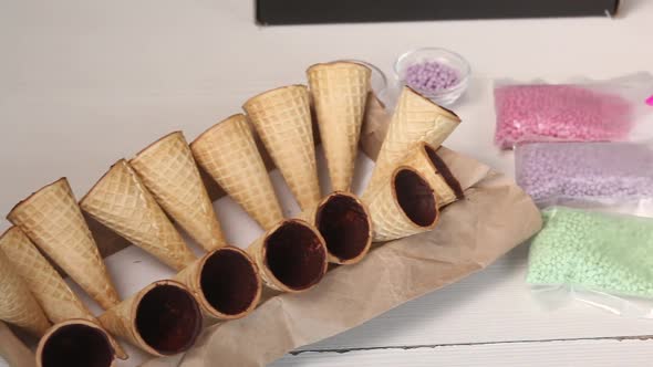 Wafer Cones Smeared Inside With Liquid Chocolate. They Are On Stands. alt