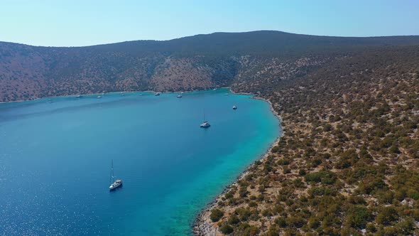 Catamaran and Sail Yachts Anchored at Bay on Deep Blue Sea Water on Sunrise alt