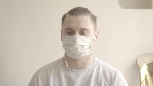 Young Man in Face Mask Agreeing with Someone in Video Chat. Portrait of Brunette Caucasian Guy with alt